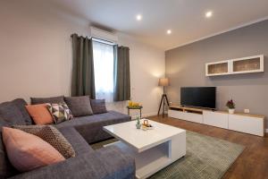 un soggiorno con divano e TV di Happy Garden Home a Spalato (Split)