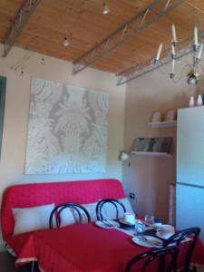 a room with a red couch and a table with chairs at Il Giardino Di Emilio in Marrùbiu