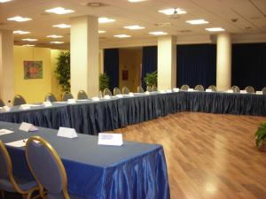 Hotel Sporting Trento في ترينتو: قاعة اجتماعات فيها طاولات وكراسي