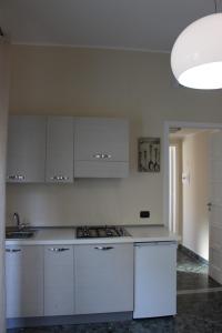 a white kitchen with white cabinets and a sink at La Casa di Aurora in Reggio di Calabria