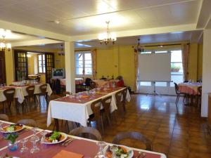 une salle à manger avec des tables, des chaises et un tableau blanc dans l'établissement Chambres d'hôtes - Domaine de la Grangeotte, à Labesserette