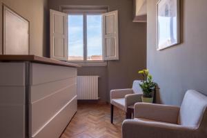 una sala de espera con 2 sillas y una ventana en Residenza d'Epoca Visacci, en Florencia