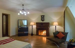 a bedroom with a fireplace and a bed and a chair at Penthouse Apartment with Panoramic Views in Tbilisi City