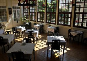 a restaurant with tables and chairs in a room with windows at União - Guest House in Tomar