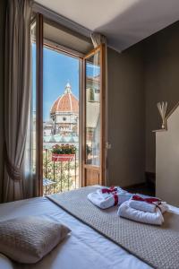 a bedroom with a bed and a balcony with a building at Residenza d'Epoca Visacci in Florence