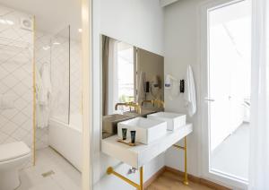 a white bathroom with two sinks and a mirror at Colors Urban Hotel Thessaloniki in Thessaloniki