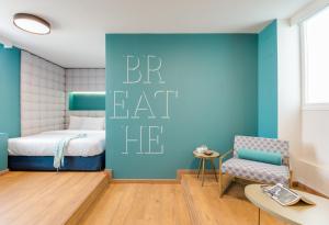 - une chambre avec un lit et un mur bleu dans l'établissement Colors Urban Hotel Thessaloniki, à Thessalonique