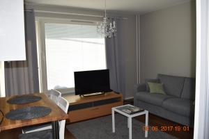 a living room with a couch and a table with a television at City Apartment Kauppakatu with Sauna in Iisalmi