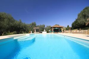 einen großen blauen Pool mit Pavillon in der Unterkunft I Ruderi, Ville di Charme in Capalbio