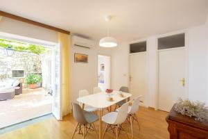 a dining room with a white table and chairs at Apartment Hedera A13 in Dubrovnik