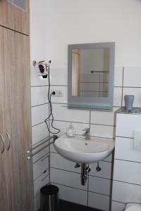 a bathroom with a sink and a mirror at Deichschaf in Dornumersiel