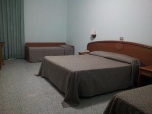 a hotel room with two beds and a nightstand at Hotel Eden in San Domino