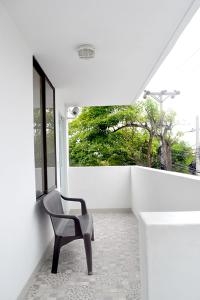 a chair sitting on a balcony with a window at Hotel Las Margaritas Alojamientos in Barranquilla