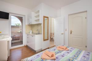 a bedroom with a bed and a sink and a kitchen at House Coko in Baška Voda +88 photos