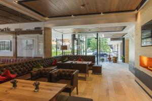 a restaurant with couches and tables and a fireplace at Hotel Niederreiter in Maria Alm am Steinernen Meer