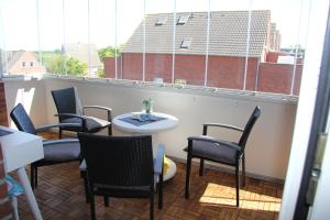 a group of chairs and a table on a balcony at Kleine Seenadel in Dornumersiel