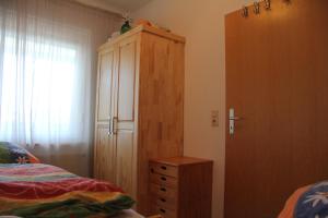 a bedroom with a bed and a wooden cabinet at Kleine Seenadel in Dornumersiel