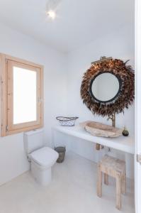 a bathroom with a toilet and a mirror at Boho Suites Denia in Denia