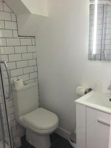 a white bathroom with a toilet and a sink at Happy Return Hotel in Blackpool