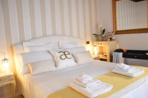 ein Schlafzimmer mit einem weißen Bett und Handtüchern darauf in der Unterkunft Historic Center - Elegant Apartment with Charming Antiques - Raffaello Inn in Rom