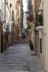 un vicolo vuoto con delle persone che camminano per esso di Vincenti Strait Street Suite a La Valletta