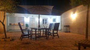 a patio with a table and chairs and an umbrella at La Casa De La Puebla in La Puebla de Montalbán