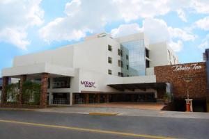 un gran edificio blanco con un cartel. en Tabasco Inn, en Villahermosa