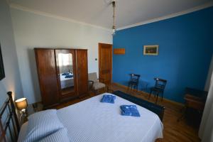 Habitación azul con una cama con toallas azules. en My Home In Olympus, en Pyrgetós