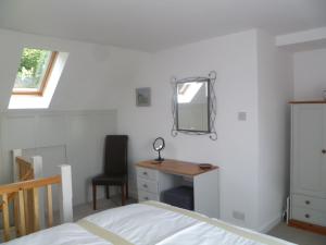 a bedroom with a bed and a desk and a mirror at The Nook @ Drop Anchor in Portishead