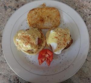 a plate of food with eggs and a strawberry on it at Polish Princess Guest House in Port Antonio