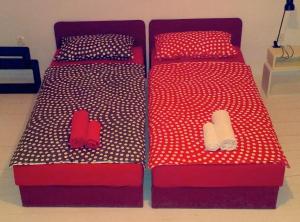 2 bedden met rode en witte stippellijnen en slippers bij Houses of Motovun in Motovun