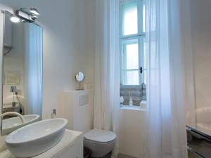 biała łazienka z umywalką, toaletą i oknem w obiekcie Valsabbion City Suite w Puli +37 zdjęć