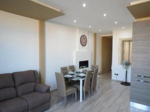 a dining room with a table and chairs and a couch at The Ivies in Mosta