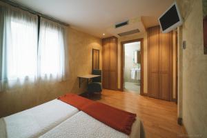 a bedroom with a bed and a desk and a television at Hotel Castillo de Javier in Pamplona