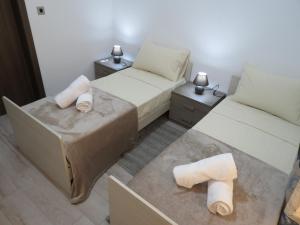 Zimmer mit 2 Betten, einem Sofa und 2 Tischen in der Unterkunft The Ivies in Mosta