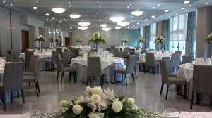 una sala de banquetes con mesas, sillas y flores en Hotel Ciudad De Ponferrada, en Ponferrada