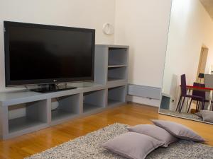 een woonkamer met een flatscreen-tv op een entertainmentcentrum bij Studio OM by Valsabbion in Medulin