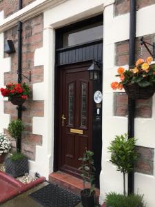 a brown door on a brick house with flowers at No 29 Bed and Breakfast in Inverness