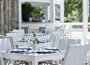 a white table and chairs with plates and glasses at San Marco Hotel and Villas in Houlakia