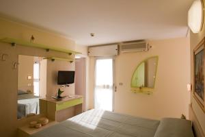 a bedroom with a bed and a mirror at Hotel Rio Bellaria in Bellaria-Igea Marina
