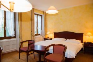 a bedroom with a bed and a table and chairs at Hotel de Bahyse in Blonay