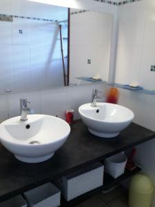 two white sinks on a counter in a bathroom at villa piscine majoma in Sainte-Anne