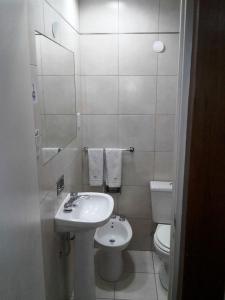 Baño blanco con lavabo y aseo en Hotel Milena en Mendoza