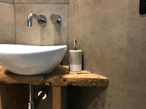 a white sink on a wooden table in a bathroom at bednextdoor in Middelburg +31 photos