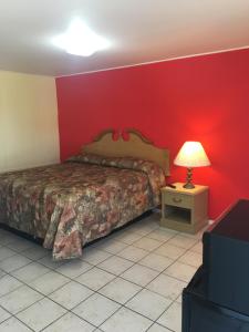 a bedroom with a bed and a red wall at Shelton Motel in Rio Grande