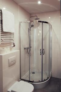 uma casa de banho com um chuveiro, um WC e um lavatório. em Cracovia em Cracóvia