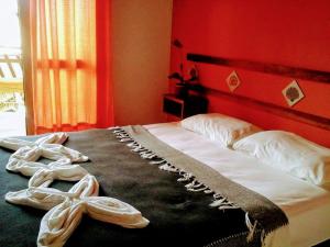 Un dormitorio con una cama con zapatos. en Pousada Thalud, en Imbassai