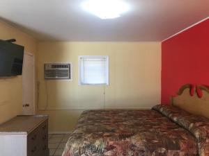 a bedroom with a bed and a window and a tv at Shelton Motel in Rio Grande