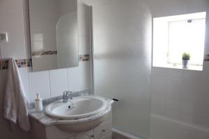 een witte badkamer met een wastafel en een douche bij Cozy Rooms Vila do bispo in Vila do Bispo
