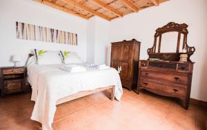 Schlafzimmer mit einem Bett, einer Kommode und einem Spiegel in der Unterkunft Casa da Lagoa AL 416 in Fajã da Caldeira de Santo Cristo